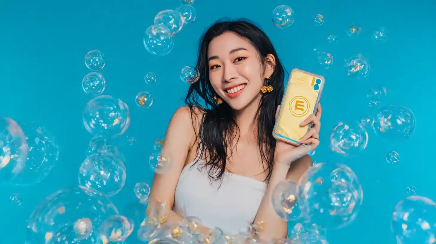 หญิงสาวไทยยิ้มถือโทรศัพท์ล้อมรอบด้วยฟองสบู่
